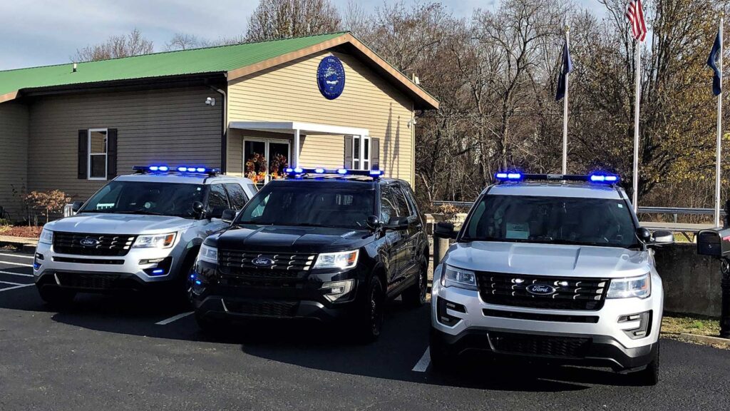 Campbellsville Police Department patrol vehicles parked outside the department building with emergency lights activated.